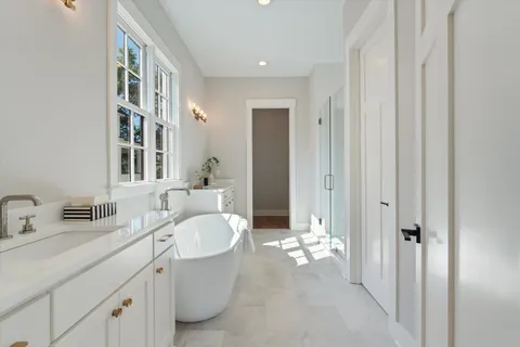 a bathroom with a double vanity sink mirror and bathtub