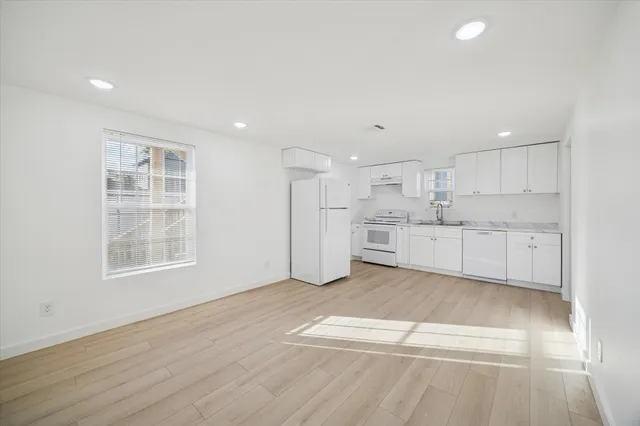 a view of a kitchen with wooden floor and windows