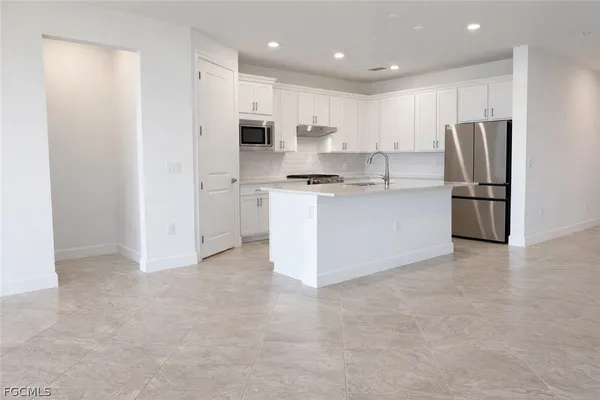 a kitchen with stainless steel appliances a refrigerator stove a sink and a refrigerator