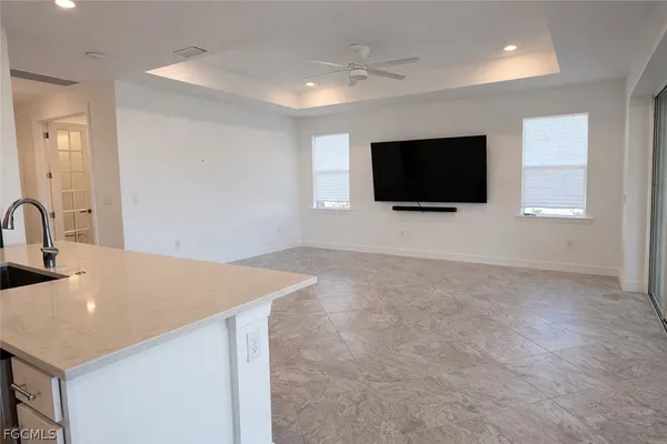 a living room with a flat screen tv and kitchen view