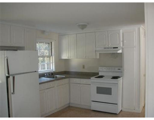 181 Seabrook Road, Unit 1 Barnstable, MA 02601 - Photo 4 of 8 a kitchen with white cabinets and white appliances