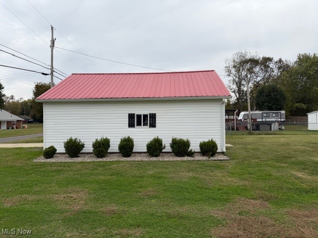 1097 Old River Road Boaz, WV 26187 - Photo 18 of 21 View of side of home with a yard and a metal roof