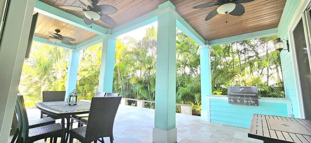 a kitchen with stainless steel appliances granite countertop a table chairs stove and refrigerator