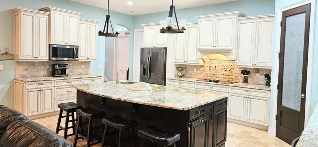 a kitchen with a stove a sink dishwasher a kitchen island with wooden cabinets and floor