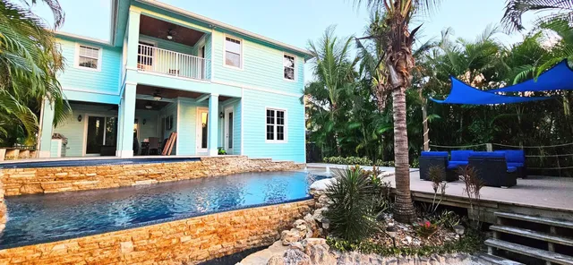 a view of a house with backyard sitting area and garden