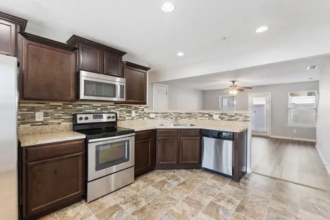 a kitchen with stainless steel appliances granite countertop a stove top oven and sink