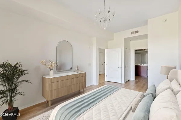 a spacious bedroom with a bed and a chandelier