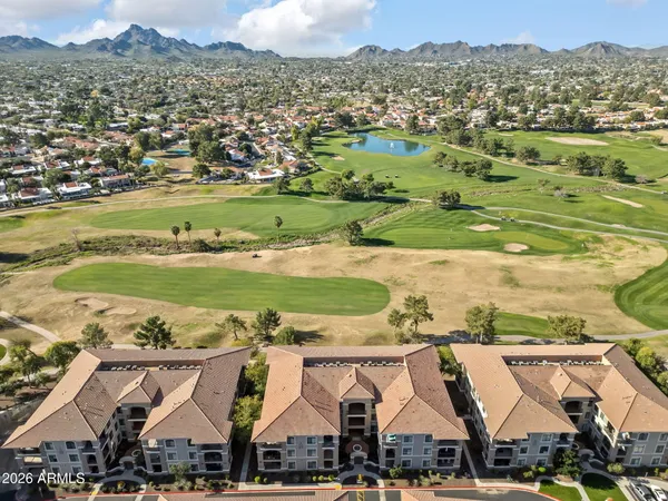 an aerial view of residential houses with outdoor space and ocean view