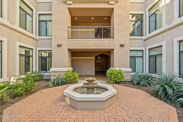 a front view of a house with a yard and fountain