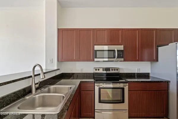 a kitchen with stainless steel appliances granite countertop a sink stove and microwave