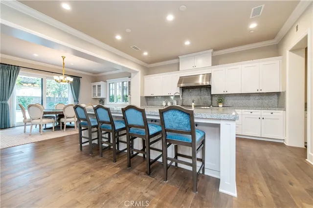 a large kitchen with stainless steel appliances lots of counter space and wooden floor