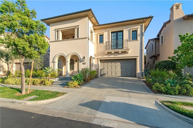 a front view of a house with a garden and trees