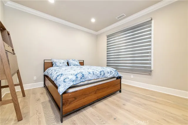 a spacious bedroom with a bed and wooden floor