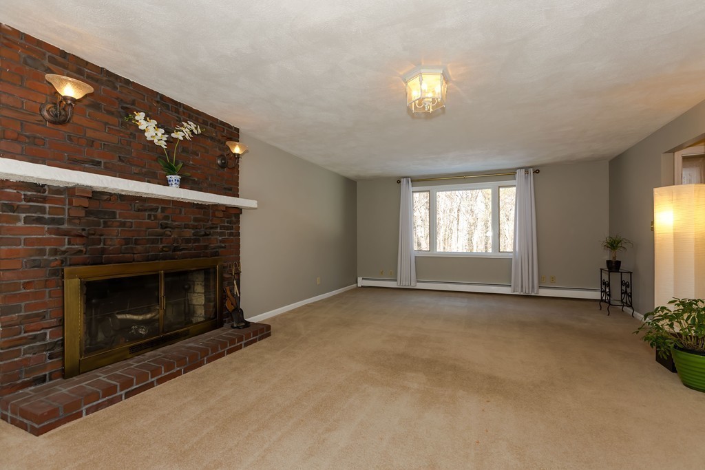 171 Taylor Road Stow, MA 01775 - Photo 6 of 18 a view of an empty room with chandelier fan and fire place