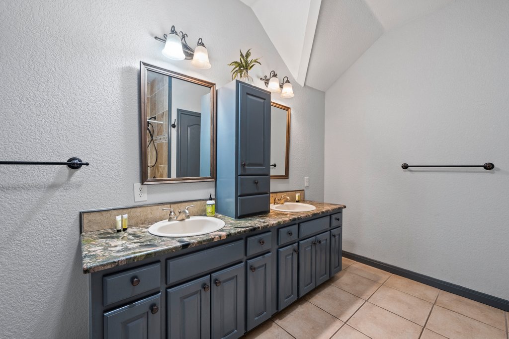 209 Lakeview Circle Spring Branch, TX 78070 - Photo 23 of 40 Full bathroom with double vanity, tile patterned flooring, a sink, and lofted ceiling