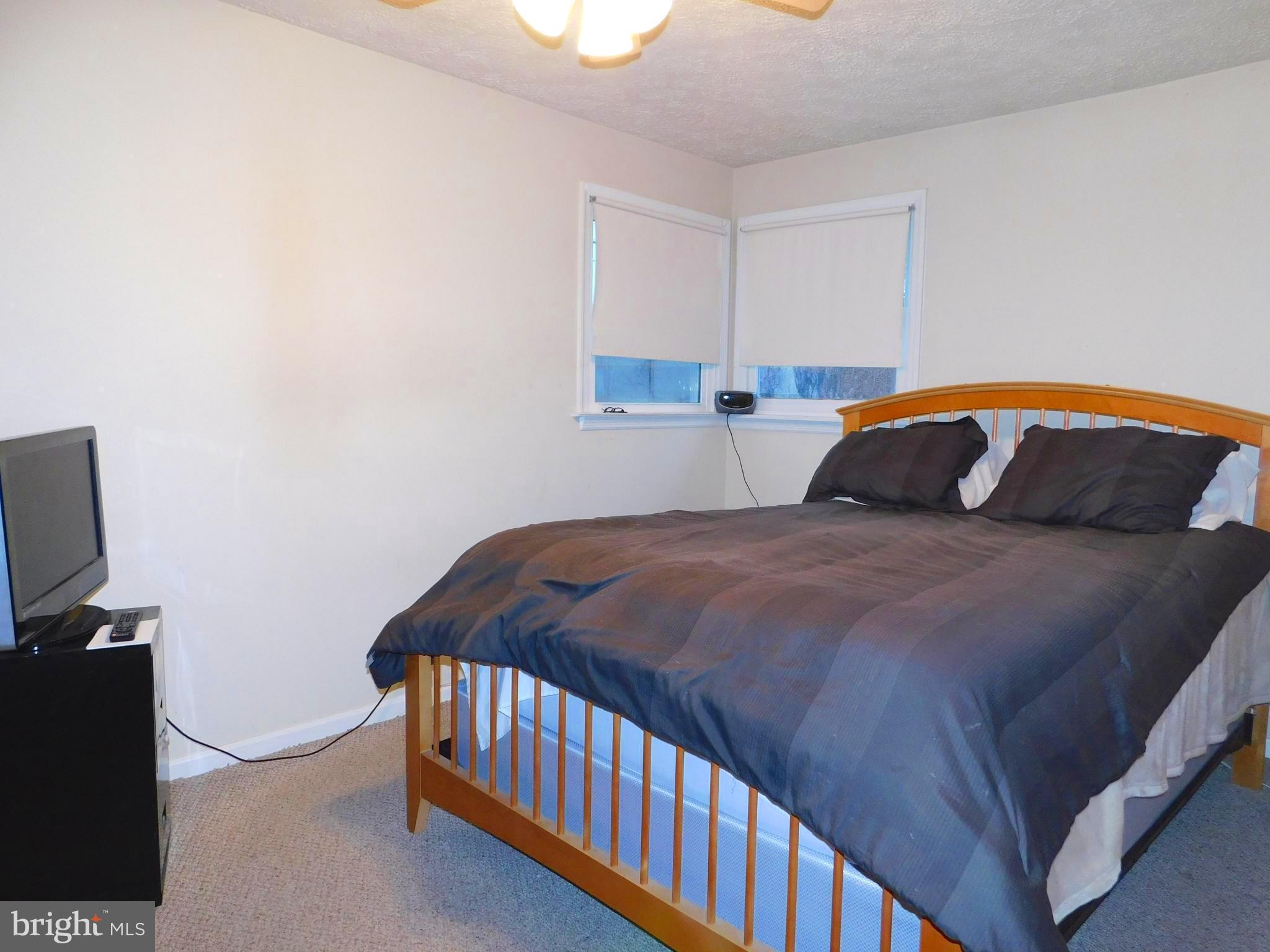 224 Cheddington Road Linthicum, MD 21090 - Photo 4 of 18 a bedroom with a bed and a television