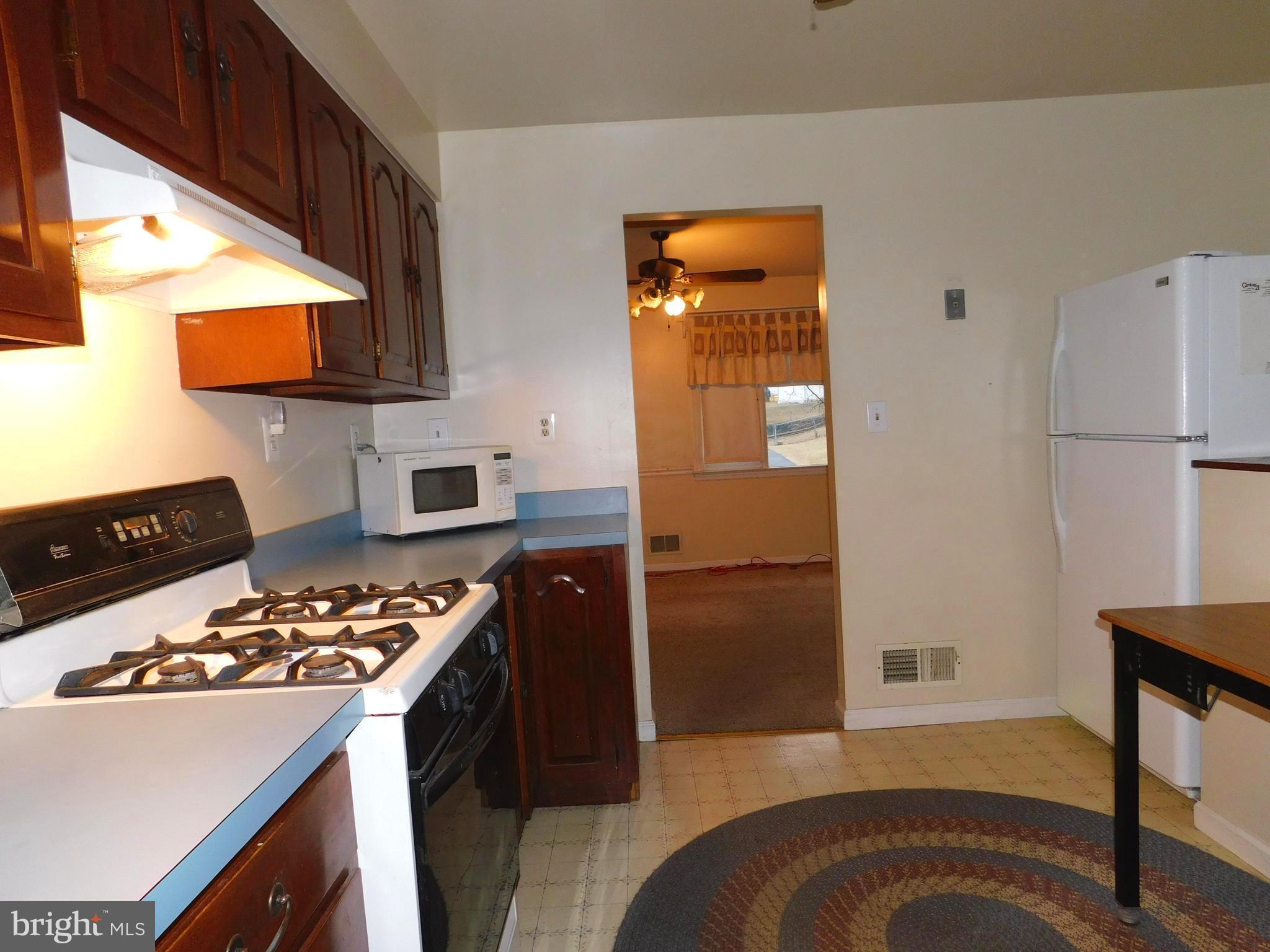 224 Cheddington Road Linthicum, MD 21090 - Photo 10 of 18 a kitchen with a refrigerator and a stove top oven