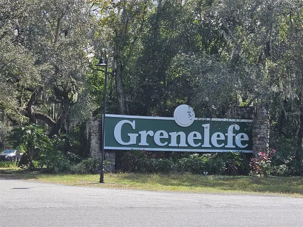 a view of sign board with large trees
