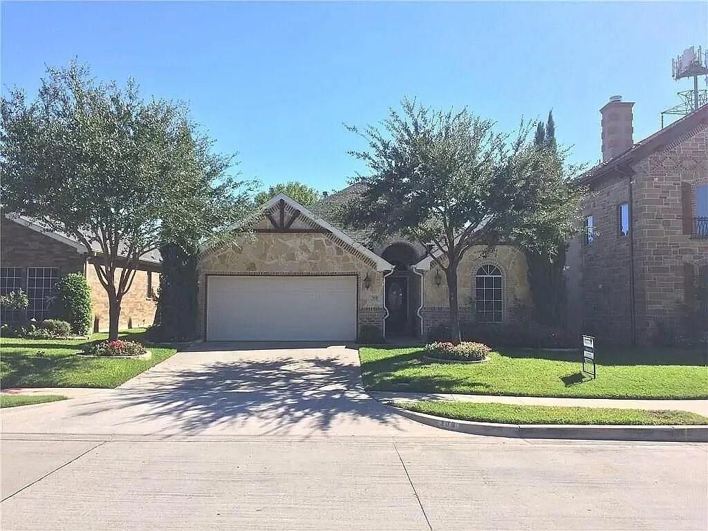 308 Ouida Road Irving, TX 75061 - Photo 1 of 16 Stone-façade residence featuring a two-car garage, arched entry, and prominent gable