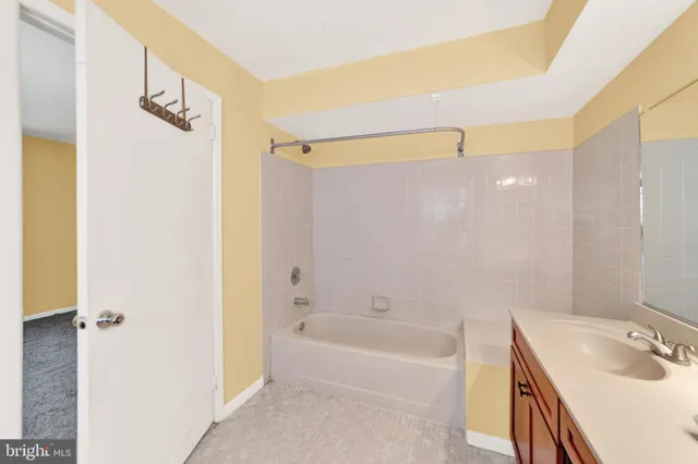 a bathroom with a tub sink and mirror