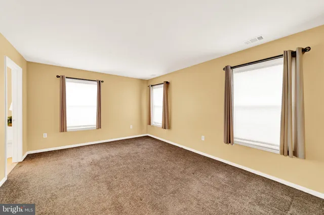 an empty room with windows and closet