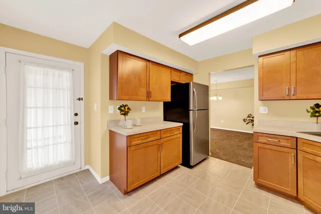 a kitchen with a refrigerator sink and cabinets