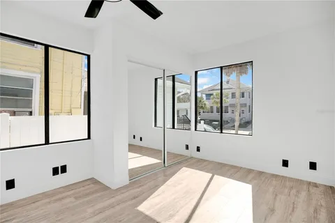 a view of an empty room with window and wooden floor
