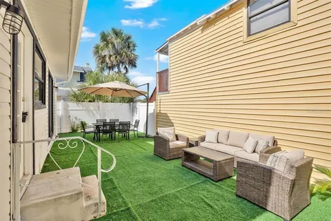 a view of a patio with couches chairs and a yard