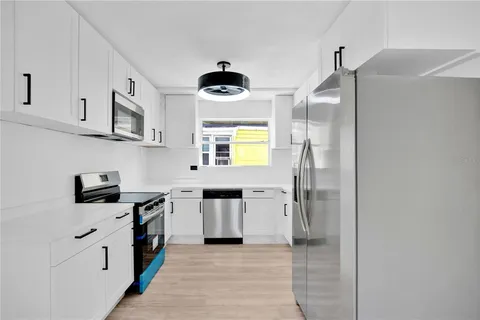 a kitchen with stainless steel appliances a stove a refrigerator and a sink
