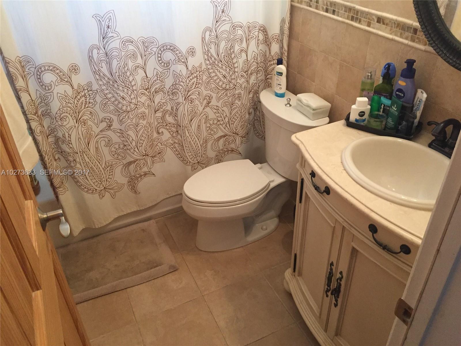 5886 Southwest 42nd Street Miami, FL 33155 - Photo 8 of 15 a white toilet sitting next to a bathroom sink