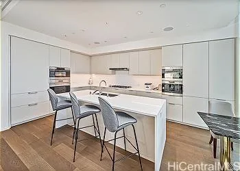 a kitchen with stainless steel appliances kitchen island granite countertop a table chairs microwave and sink