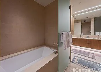 a bathroom with a tub sink and mirror