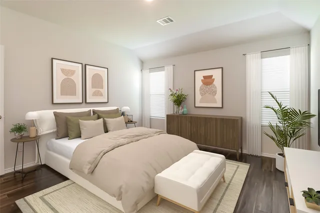 a bedroom with a large bed and wooden floor