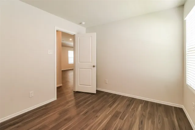 an empty room with wooden floor and white walls