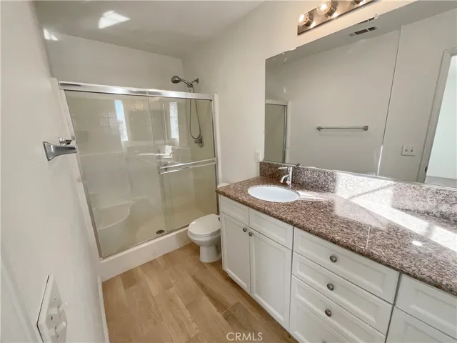 a bathroom with a granite countertop sink toilet and shower