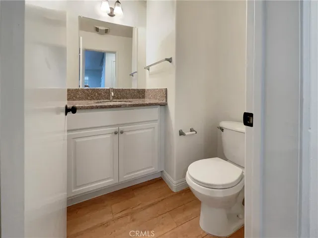 a bathroom with a granite countertop toilet sink and mirror