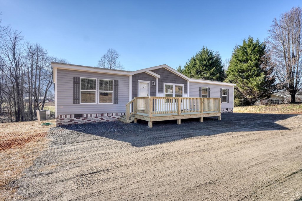 2045 Upper Bell Creek Road Hiawassee, GA 30546 - Photo 2 of 47 a view of a house with a wooden deck and a yard