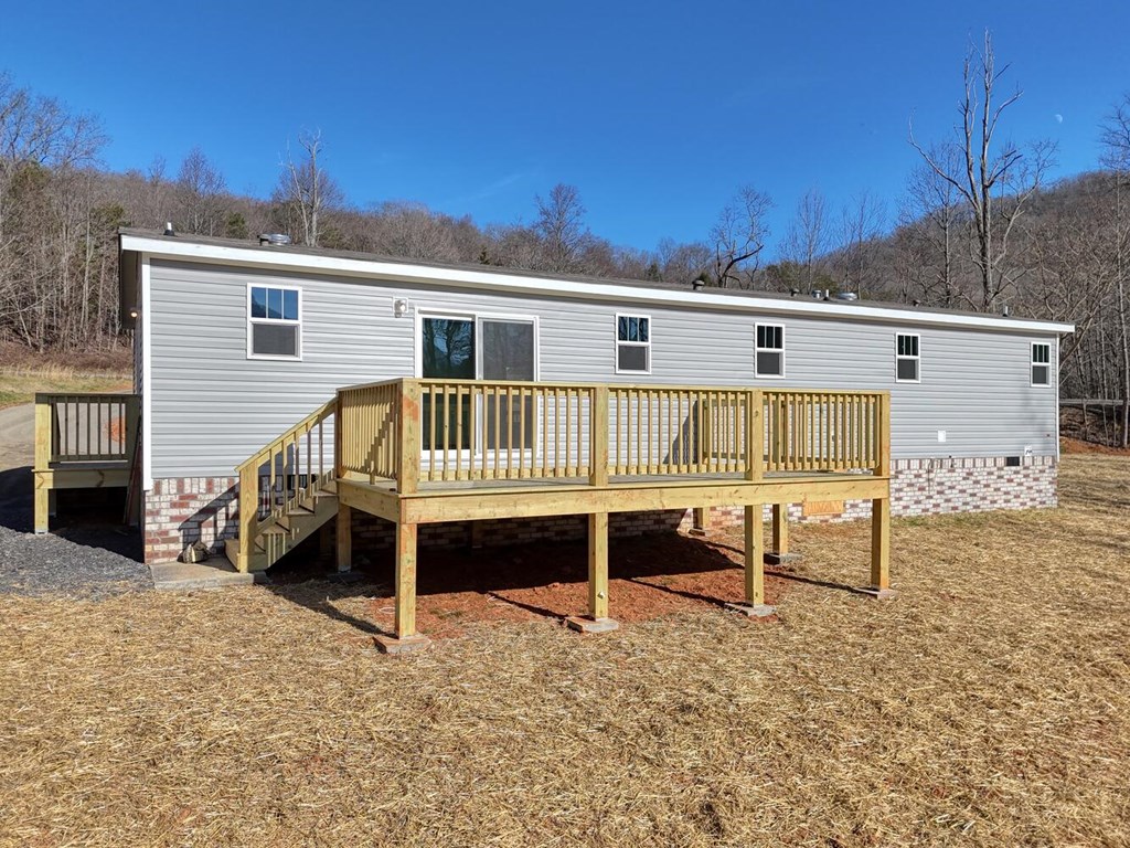 2045 Upper Bell Creek Road Hiawassee, GA 30546 - Photo 6 of 47 a view of a house with a wooden deck and a yard