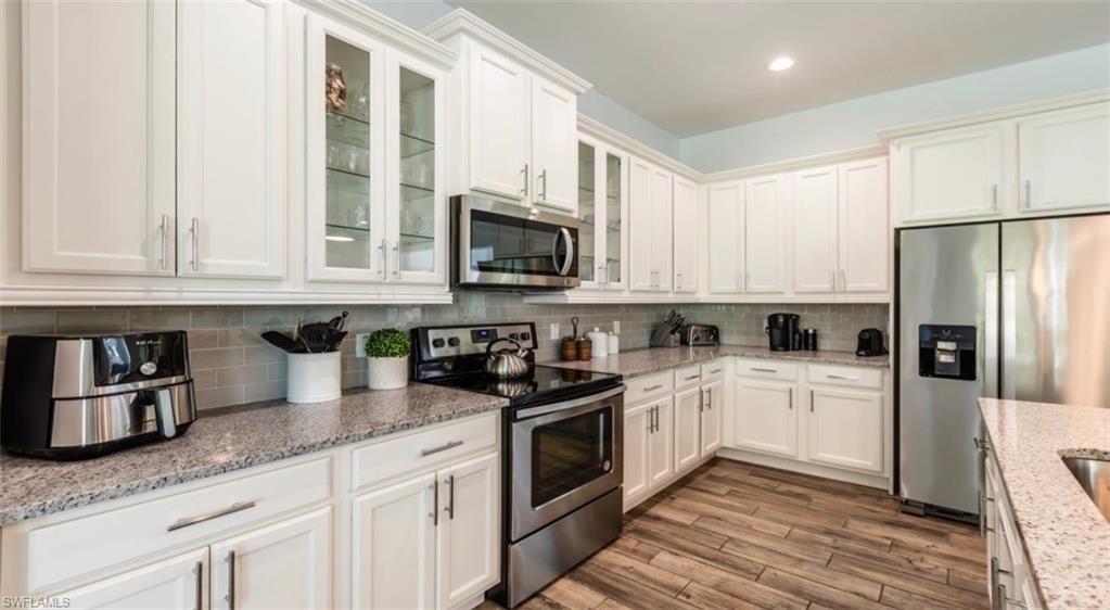 118 Bermuda Road Marco Island, FL 34145 - Photo 3 of 16 a kitchen with granite countertop white cabinets and stainless steel appliances