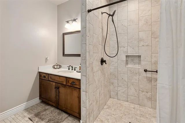 a bathroom with a sink vanity and shower