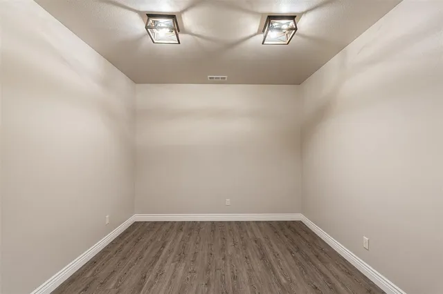 a view of a small space with wooden floor and a window