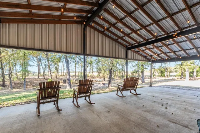 a view of a chairs and table in patio with a yard