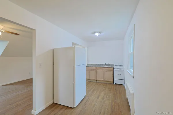 a view of a kitchen with a sink and dishwasher a refrigerator with wooden floor