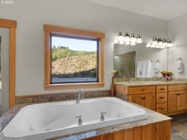 a bathroom with a tub a sink and a mirror
