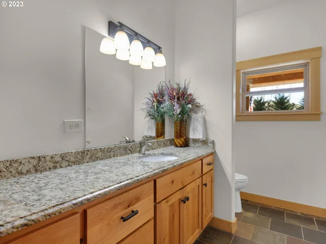 a bathroom with a granite countertop sink and a mirror