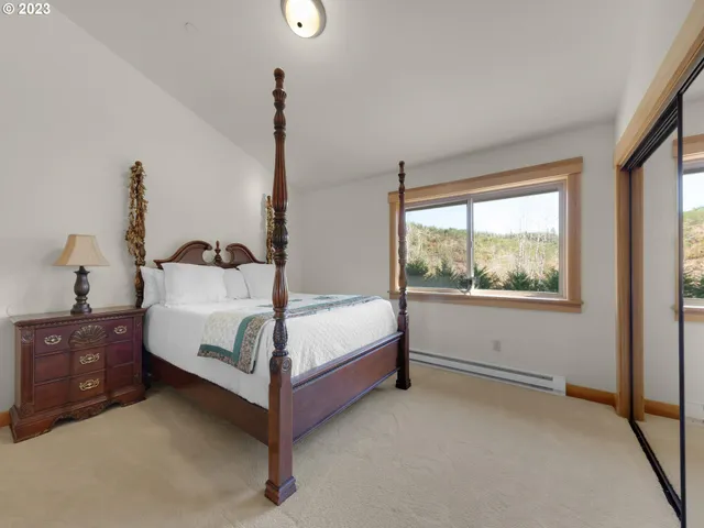 a white bed sitting in a room next to a window