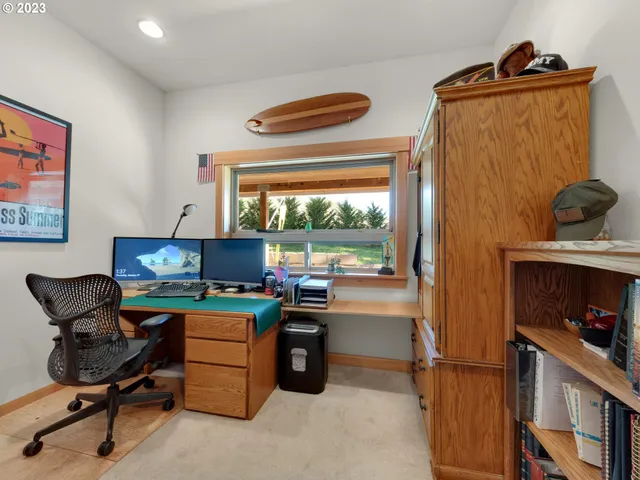 a view of a workspace with furniture and a window