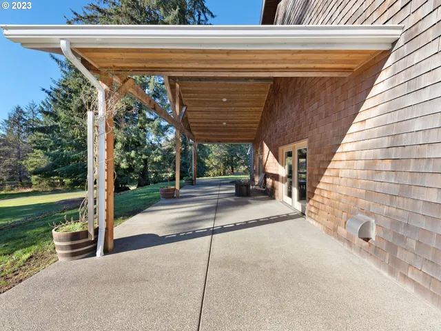 a view of a patio with a table and chairs and floor to ceiling window with wooden fence