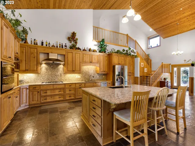 a kitchen with stainless steel appliances kitchen island granite countertop a table and chairs in it