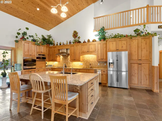 a dining table with chairs and kitchen view